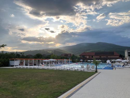 a resort with a pool and chairs and mountains at Hotel Ashad in Svalyava