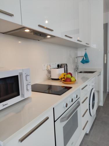 a white kitchen with a bowl of fruit on the counter at Your Four Seasons in Boğaz