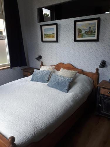 a bedroom with a white bed with two pillows at De Malle Molen in Dinxperlo