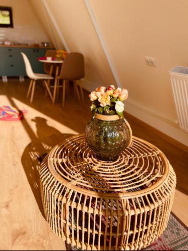 a vase with flowers on top of a wicker table at Sno Cottage in Sno