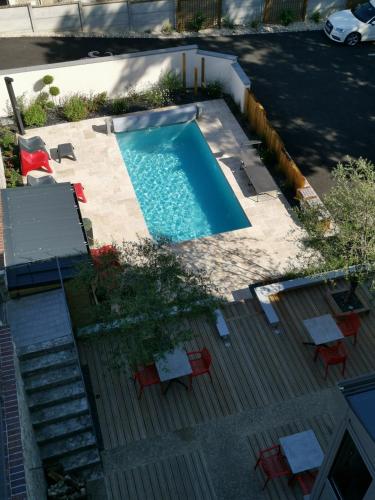 an overhead view of a swimming pool with tables and chairs at Lamarck Guest in Bourges