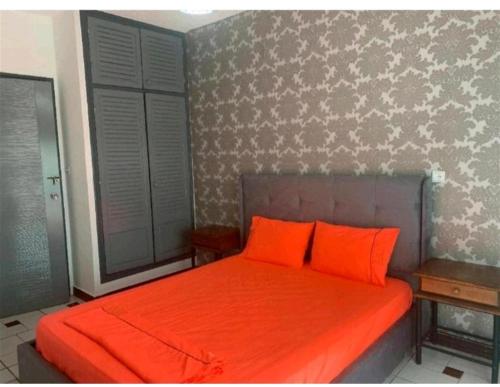 an orange bed with two orange pillows in a bedroom at Bel appartement à Ifrane in Ifrane