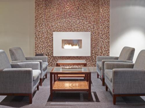 a waiting room with chairs and a table and a fireplace at Tyrifjord Hotell in Vikersund