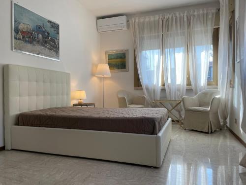 um quarto com uma cama, uma cadeira e uma janela em Villa Irene Apartments em Mestre