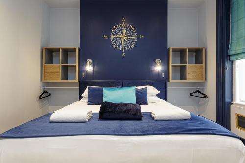 - une chambre avec un grand lit aux murs bleus dans l'établissement Cormorant PLACE LUXURY PAD, à Portsmouth