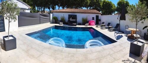 basen w ogrodzie z krzesłami wokół niego w obiekcie La Suite Côté Pool-House Piscine, Sauna & Jacuzzi privatifs w mieście Istres