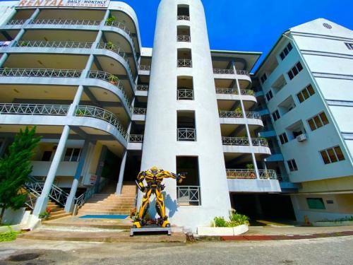 a large building with a statue in front of it at Perdana Serviced Apartment & Resorts in Kampung Padang Masirat