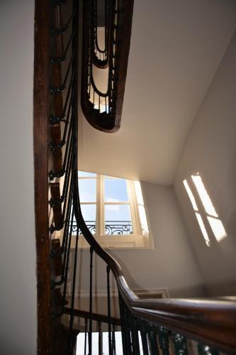 a spiral staircase in a building with a window at Le Jardin des Lys in Saint-Léonard-de-Noblat