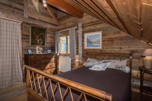 ein Schlafzimmer mit einem Bett in einem Blockhaus in der Unterkunft Magnifique chalet en rondins avec sauna - Vercors in Villard-de-Lans