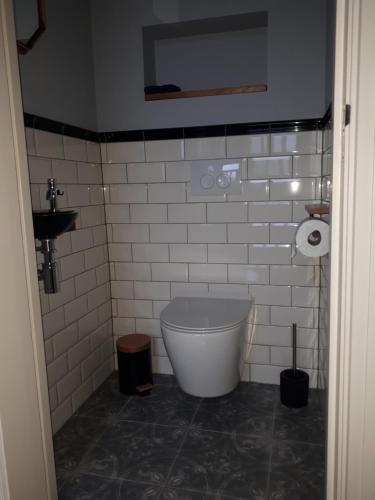 een badkamer met een bad in een witte betegelde muur bij De Malle Molen in Dinxperlo