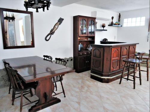 a kitchen with a wooden table and a mirror at Villa Gallo - Seminterrato luminoso in Capoterra