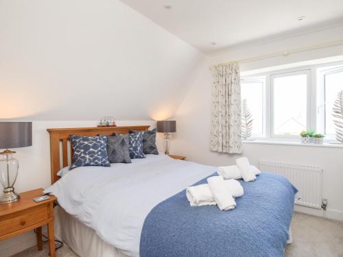 a bedroom with a large bed with towels on it at Lobster Lookout in Swanage