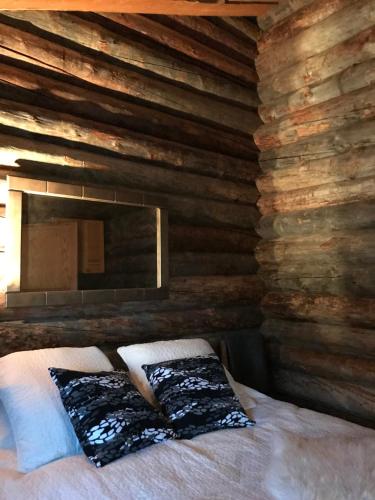 a bedroom with a bed in a wooden wall at Iso-Syötteen Kelokolo Soarvesalvu in Syöte
