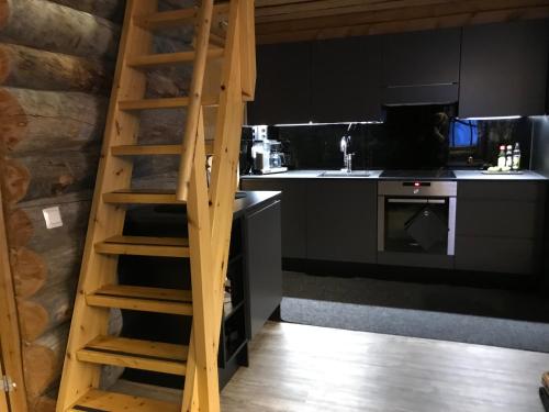 a kitchen with a wooden ladder in a kitchen at Iso-Syötteen Kelokolo Soarvesalvu in Syöte