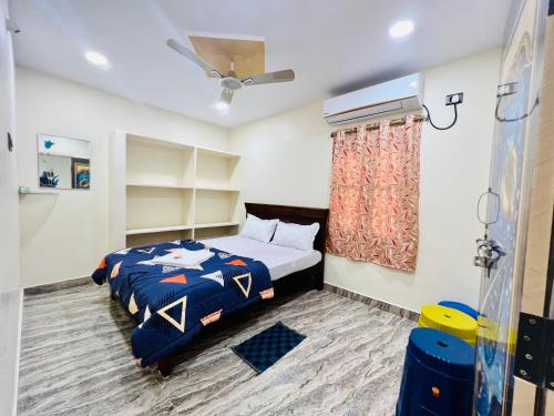 a bedroom with a bed with a blue comforter at V Homestays in Bhadrāchalam
