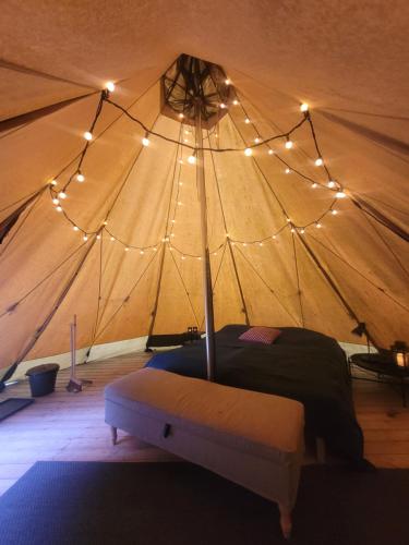 a bedroom with a bed in a tent with lights at Södra Lund B&B in Vreta Kloster