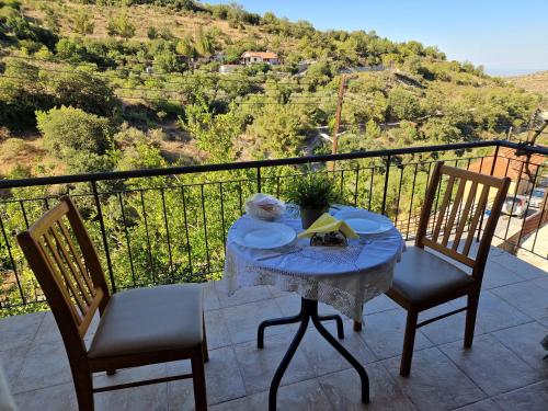 a table and chairs on a balcony with a view at Arsos Village Apartment in Arsos