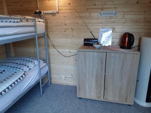 Habitación con 2 literas y escritorio con hervidor de agua. en Die Radlerhütte - NUR FÜR EINE NACHT - en Ankelohe