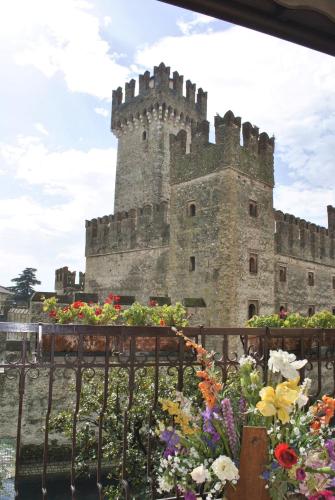a castle with a bunch of flowers in front of it at Hotel Grifone in Sirmione