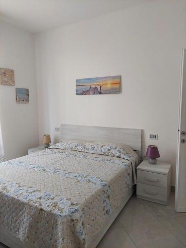 a bedroom with a bed and a painting on the wall at APPARTAMENTO CALETTA 2 in Castiglioncello
