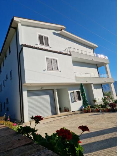 une maison blanche avec un garage dans l'établissement Villa Pulo, à Tragjas