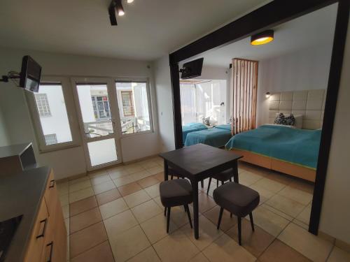 a room with a table and chairs and a bedroom at Bungalow Kapitański in Jastrzębia Góra