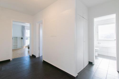 an empty room with white walls and a bathroom at Tolstov Apartments - 1 or 3 Room Apartments with Balcony - 20 Min Messe DUS & Airport DUS in Meerbusch