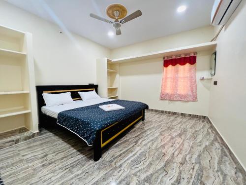 a bedroom with a bed and a window at V Homestays in Bhadrāchalam