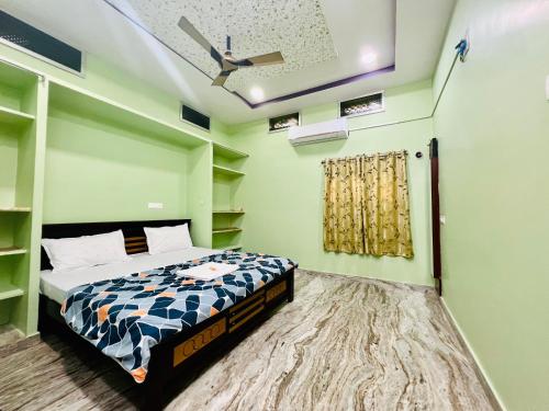 a bedroom with a bed and a ceiling fan at V Homestays in Bhadrāchalam