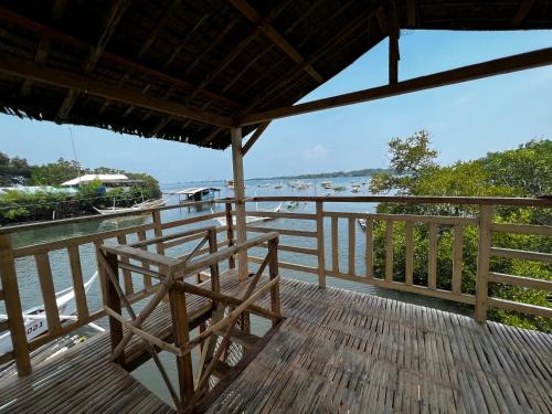 a wooden balcony with a view of the water at Onyong's Floating Cottage in Calatagan