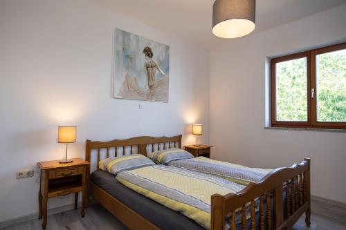 a bedroom with a wooden bed with two lamps at Bela Vista 4 Rustikales Appartement in Volosko