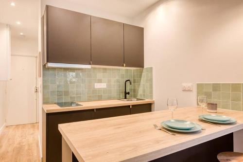 une cuisine avec une table avec des assiettes et des verres dessus dans l'établissement GemBnB Luxury Apartments - Résidence Villedo, à Paris