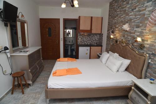 a bedroom with a large bed and a kitchen at Orama Apartments in Agia Anna Naxos