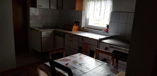 a kitchen with a table and chairs and a window at Mirni kutak in Donje Pazarište
