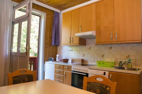 a kitchen with wooden cabinets and a stove top oven at Apartma Vila Kočna in Zgornje Jezersko