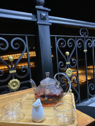 a tea pot on a wooden table with two glasses at Golden Apple Villa Đà Lạt in Khu Chi Lăng