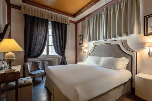 a bedroom with a bed and a desk and a window at Residenza Gambrinus in Florence