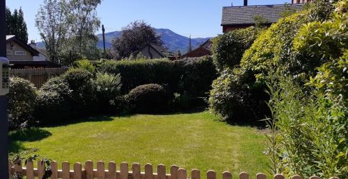 a yard with a fence and green grass at Andreu Cottage in Callander