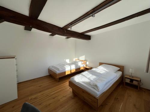 two beds in a room with wooden floors and ceilings at Ferienwohnung Ederblick in Wabern