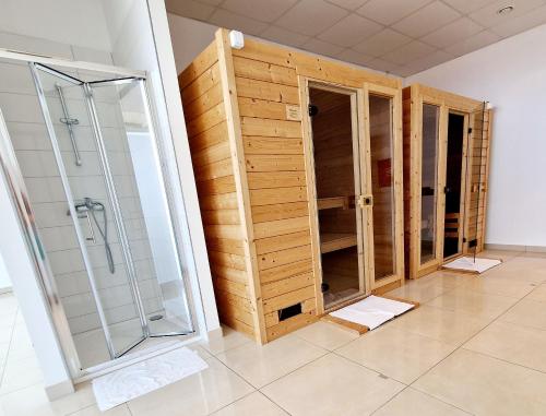 a bathroom with wooden cabinets and a glass shower at Residence-Apartment-Giuliano-Punta Skala, in Petrcane