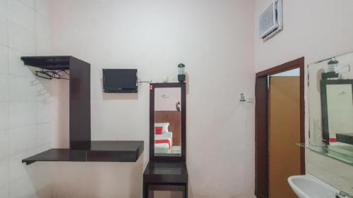 a bathroom with a mirror and a sink and a mirror at RedDoorz At Pujon Malang in Batu