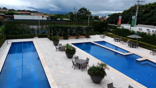 una piscina con mesas y sillas junto a un edificio en Altamira Cozy apartment with amazing views en Santo Domingo