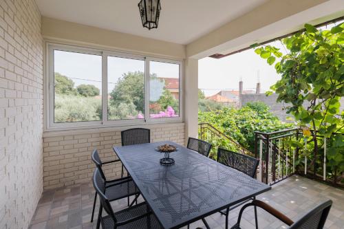 jadalnia ze stołem i krzesłami na balkonie w obiekcie Buena Vida Apartman w mieście Zadar