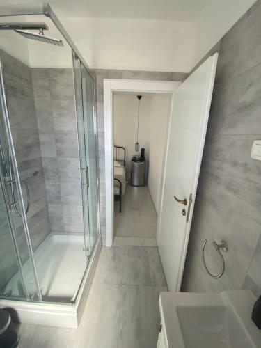 a bathroom with a walk in shower and a sink at Litore in Pula