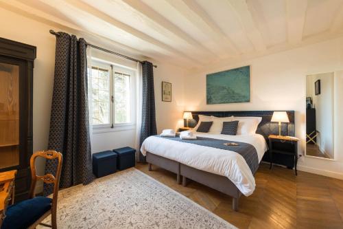 a bedroom with a large bed in a room at L'Orée du Mans in Sillé-le-Philippe