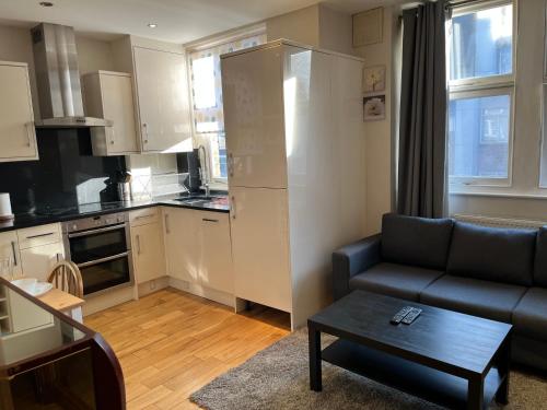 a kitchen and living room with a couch and a table at Stunning apartment in the heart of Central London in London