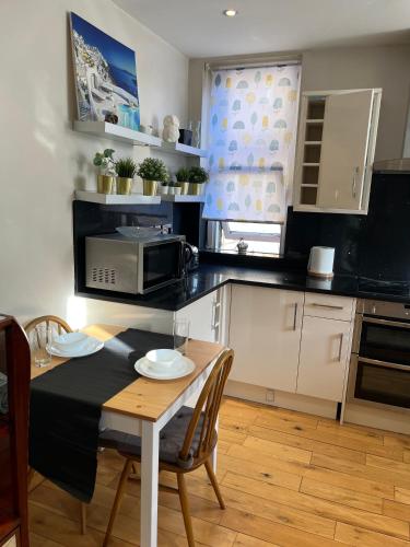 a kitchen with a table and a microwave at Stunning apartment in the heart of Central London in London