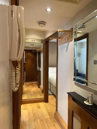 a bathroom with a mirror and a room with a bed at Stunning apartment in the heart of Central London in London