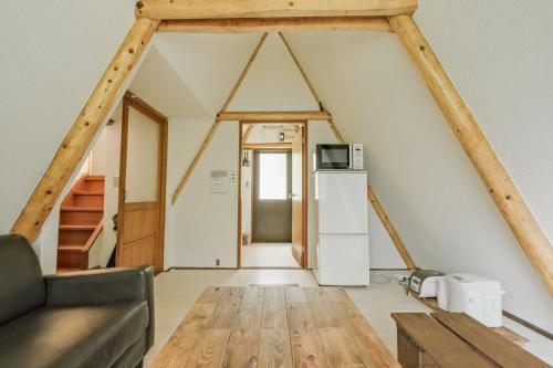 ein Wohnzimmer mit einem Sofa und einem Kühlschrank in der Unterkunft 南箱根ツリーハウス in Kannami