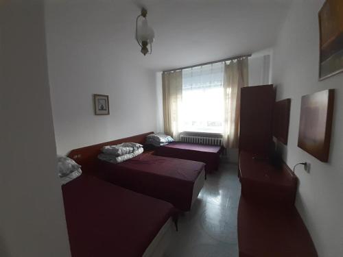 a living room with two beds and a window at OŚRODEK WYPOCZYNKOWY MAZOWSZE W KARPACZ in Karpacz